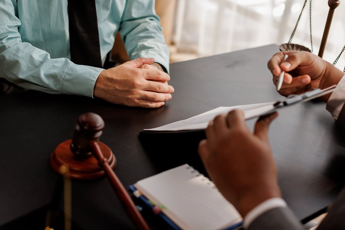 Free Legal Aid voluntary police interview solicitor presenting legal advice to a client with gavel and case documents before attending an interview under caution