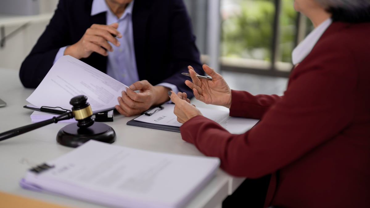 Free legal aid criminal law advice session with a legal professional consulting a client over important case documents in an office setting