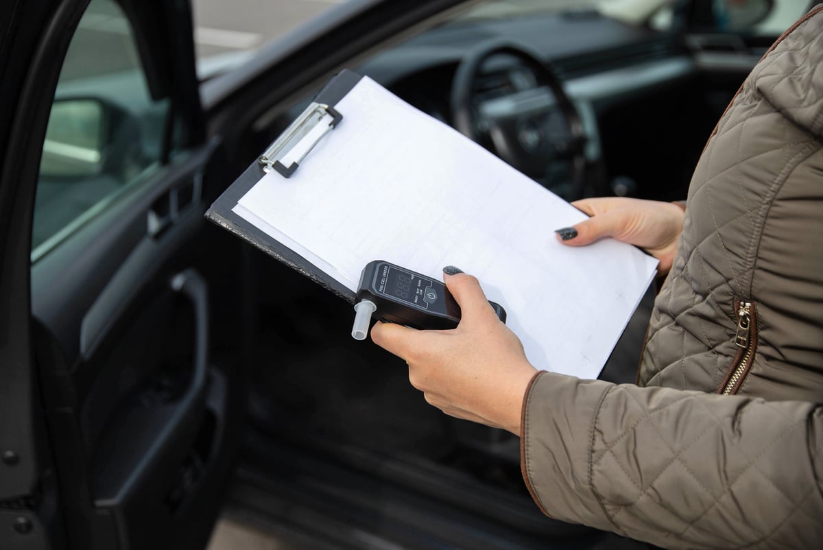 UK police officer conducting a roadside vehicle stop and search under PACE powers, checking driver documents during a lawful traffic stop in England