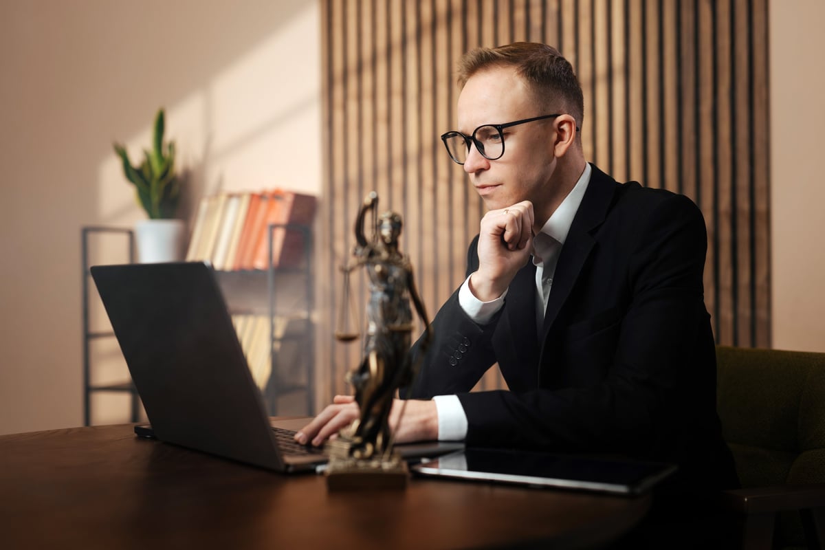 Solicitor for robbery charges analysing case documents at a desk with a statue of justice in the background